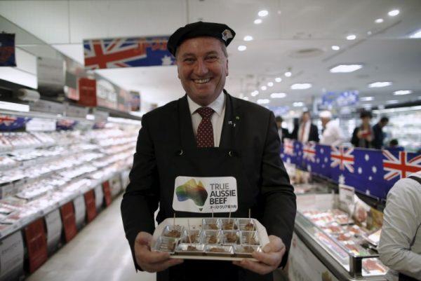 Australian Minister for Agriculture and Water Resources Barnaby Joyce smiles as he serves sampling Australian beef food to customers to promote Australian products at a supermarket in Tokyo, Japan, Nov. 16, 2015. (Reuters/Issei Kato)
