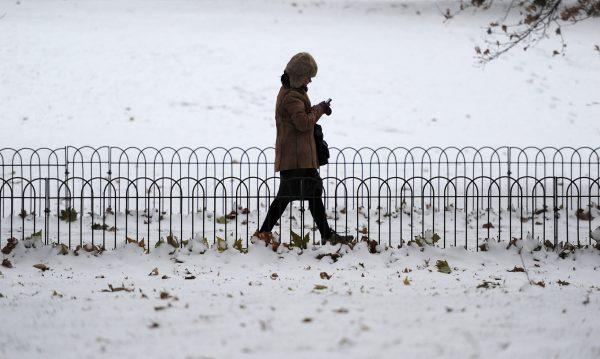 A woman uses her mobile phone as she walks through the snow in St James's Park in central London on Dec. 2, 2010. Airports were shut, trains were stranded and roads were closed in Britain amid a week-long freeze. (Carl Court /AFP/GettyImages)
