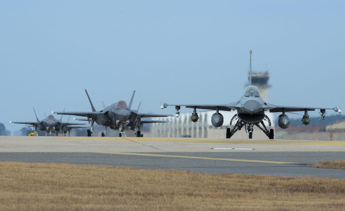 A U.S. Air Force F-16 Fighting Falcon and four F-35A Lightning IIs taxi toward the end of the runway during exercise Vigilant Ace 18 at Kunsan Air Base in South Korea on Dec. 3, 2017. The week-long, exercise is held in support of the Mutual Defense Treaty between the U.S. and Republic of Korea. (U.S. Air Force photo by Senior Airman Colby L. Hardin)