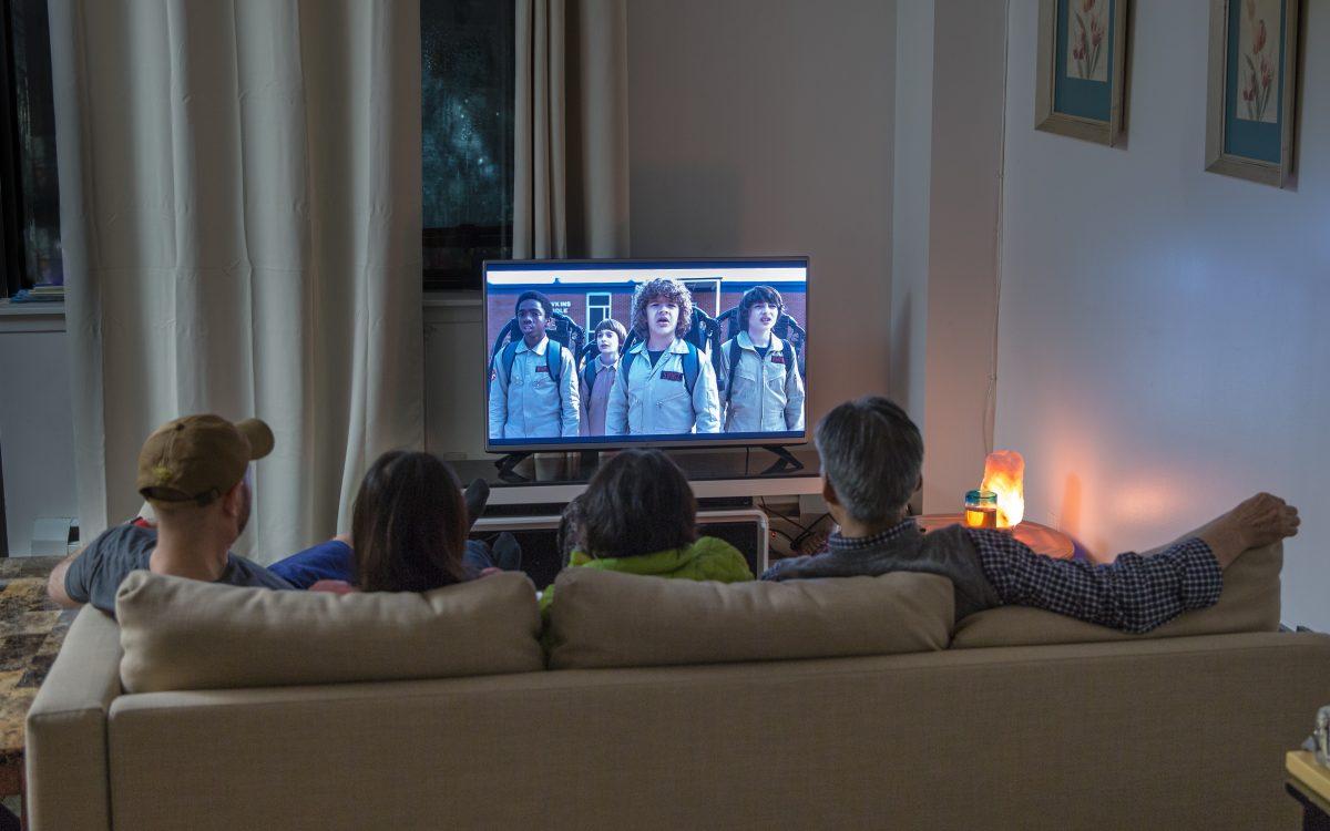 A family watches the TV series "Stranger Things," on Netflix at their home in Queens, New York, on Dec. 6, 2017. (Benjamin Chasteen/The Epoch Times)