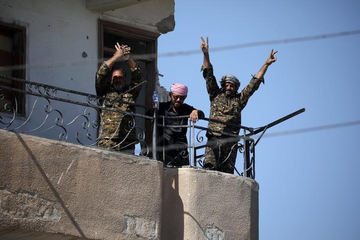 Fighters from the Syrian Democratic Forces give the "V" sign at the frontline in Raqqa, Syria on Oct. 16, 2017. (REUTERS/Rodi Said)