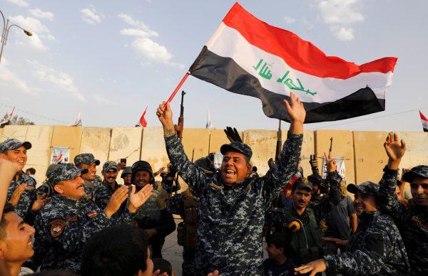 A member of the Iraqi Federal Police waves an Iraqi flag as they celebrate the victory of military operations against the ISIS terrorists in West Mosul, Iraq, on July 2, 2017. (Reuters/Erik De Castro/File Photo)