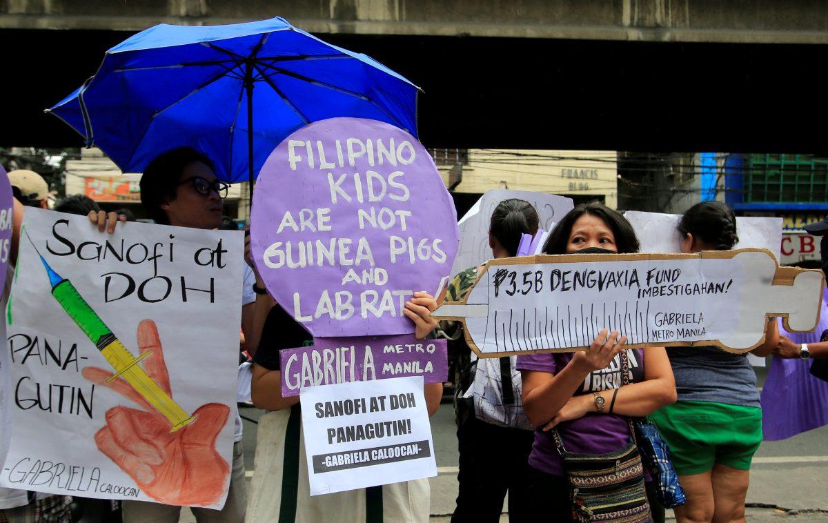 People display signs and a mock syringe, with the phrase "3.5 billion pesos Dengvaxia fund investigate" featured on it, during a protest in front of the Philippine Department of Health (DOH) in metro Manila, Philippines Dec. 5, 2017. (Reuters/Romeo Ranoco/File Photo)