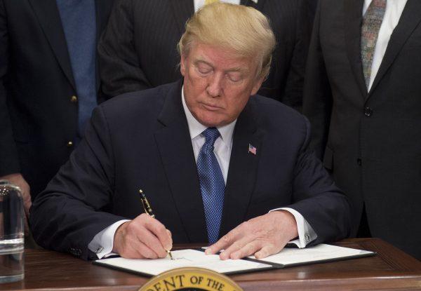 President Donald Trump signs Space Policy Directive 1, with the aim of returning Americans to the moon and eventually Mars, in the Roosevelt Room at the White House in Washington, DC, Dec. 11, 2017. (SAUL LOEB/AFP/Getty Images)