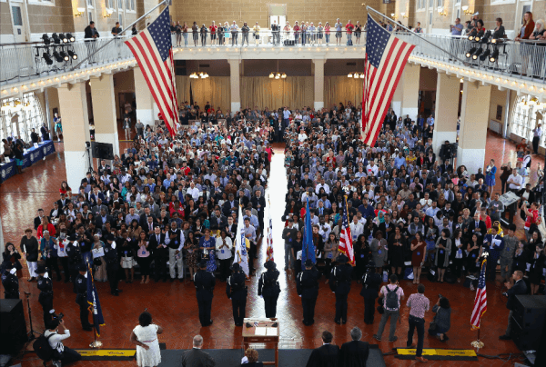 Immigrants stand for the U.S. national anthem during a naturalization ceremony in the Great Hall of Ellis Island in New York on Sept. 16, 2016. (John Moore/Getty Images)