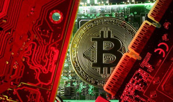 A coin representing the bitcoin cryptocurrency is seen on computer circuit boards in this picture, October 26, 2017. (REUTERS/Dado Ruvic/File Photo)