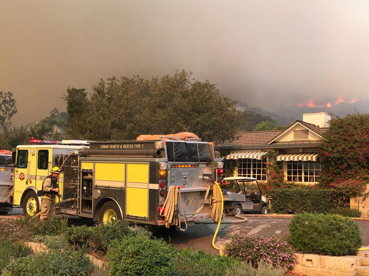 Firefighters provide structure protection at the historic San Ysidro Ranch as flames from the Thomas Fire, now the third-largest on record, rage in the distance in Montecito, California, Dec. 16, 2017. (Mike Eliason/Santa Barbara County Fire Department/Handout via Reuters)