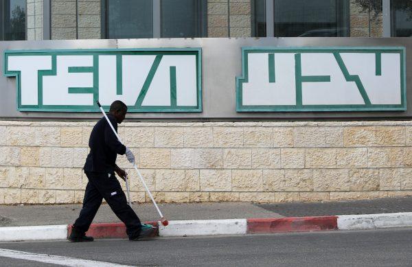 A man cleans near the logo of Teva Pharmaceutical Industries at their plant in Jerusalem December 14, 2017. (Reuters/Ammar Awad)