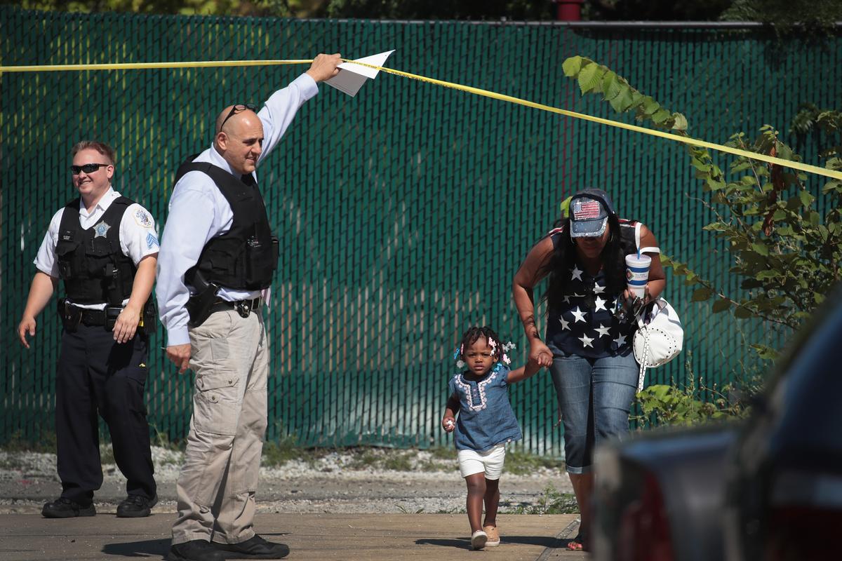 Residents are allowed to leave their home as police investigate a murder scene in the Humboldt Park neighborhood of Chicago, Ill., on July 27, 2017. The city is on a pace to top last year's total of more than 750 murders, the highest the number since the early 1990's. (Scott Olson/Getty Images)