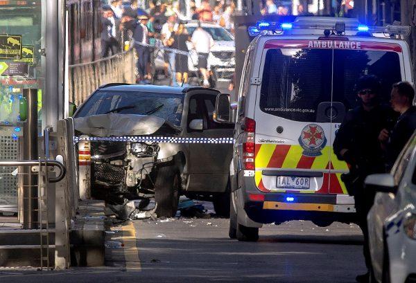 Australian police stand near a crashed vehicle after they arrested the driver of a vehicle that had ploughed into pedestrians at a crowded intersection near the Flinders Street train station in central Melbourne, Australia Dec. 21, 2017. (Reuters/Luis Ascui)