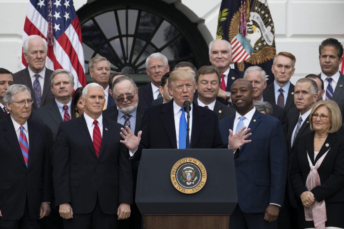 President Donald Trump celebrates the passage of the tax bill, while flanked by members of Congress, on the South Lawn of the White House in Washington, Dec. 20, 2017. (Samira Bouaou/The Epoch Times)