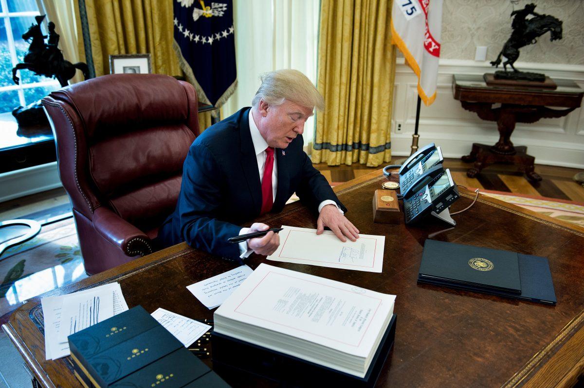 President Donald Trump signs the Tax Cut and Reform Bill in the Oval Office of the White House on Dec. 22, 2017. (Brendan Smialowski/AFP/Getty Images)