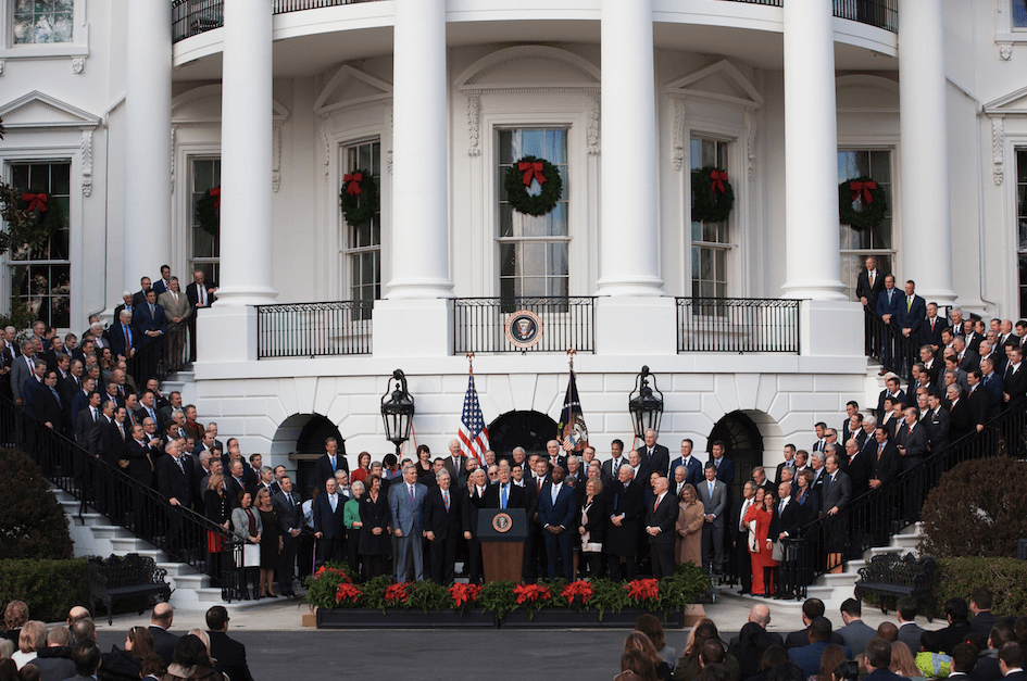 President Donald Trump celebrates the passage of the tax bill, while flanked by members of Congress, on the South Lawn of the White House in Washington, Dec. 20, 2017. (Charlotte Cuthbertson/The Epoch Times)