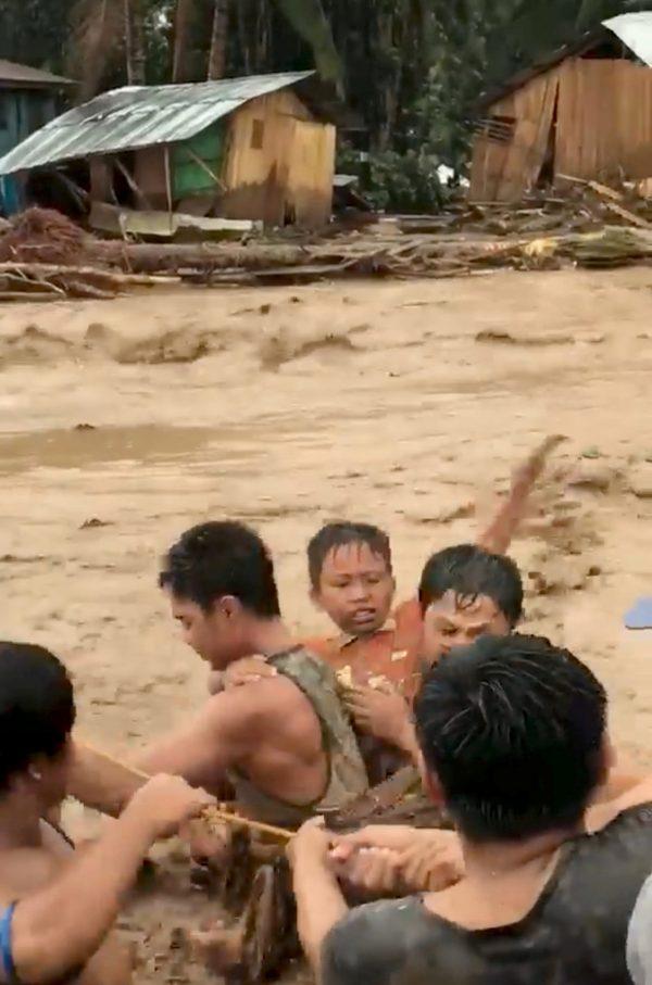 People help to rescue flood victims in Lanao del Norte, Philippines, Dec. 22, 2017 in this image taken from video footage obtained from social media. (Aclimah Cabugatan Disumala/via Reuters)