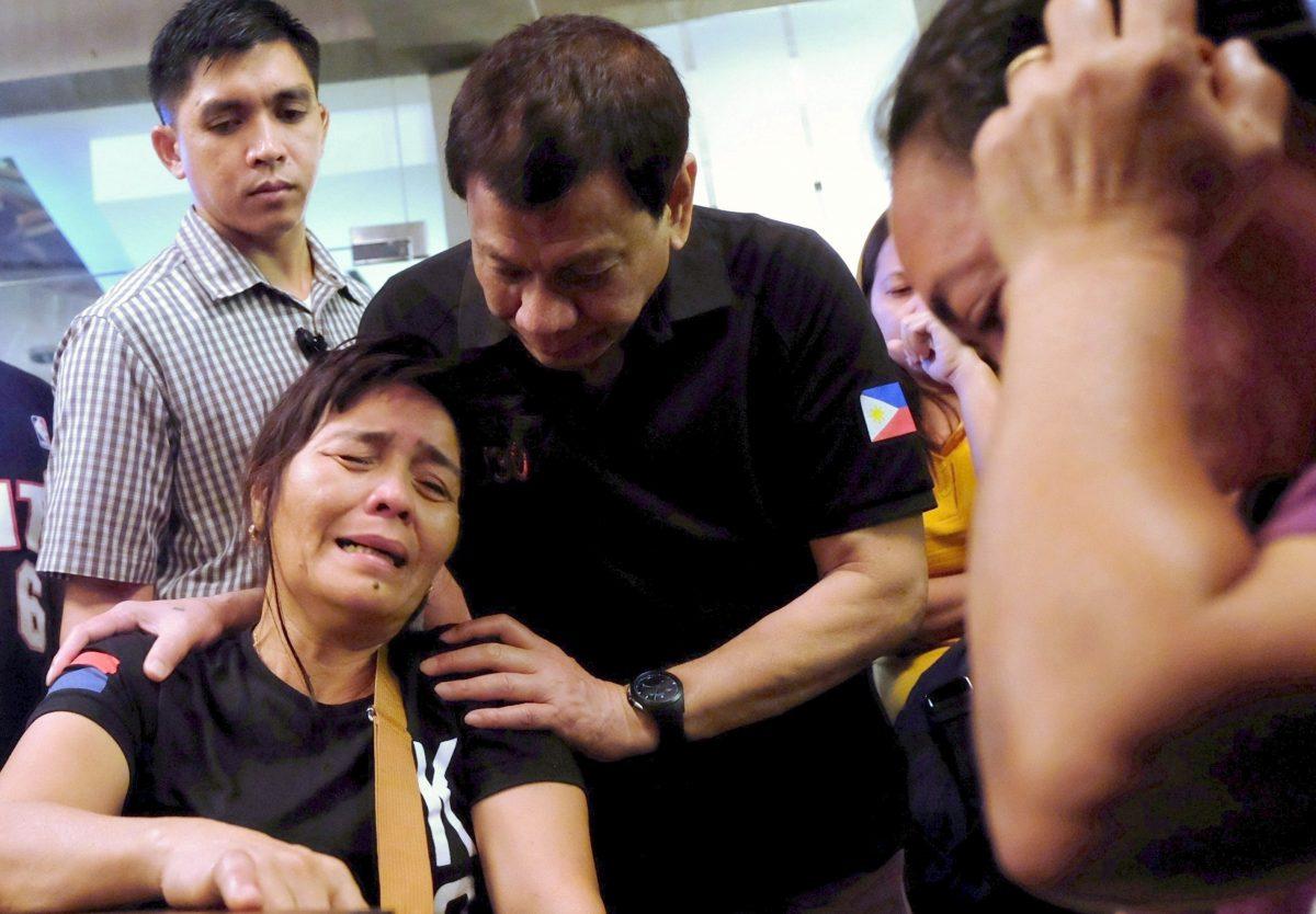 President Rodrigo Duterte comforts a family member of a fire victim in Davao city in Philippines, Dec. 24, 2017. (Reuters/Presidential Palace)