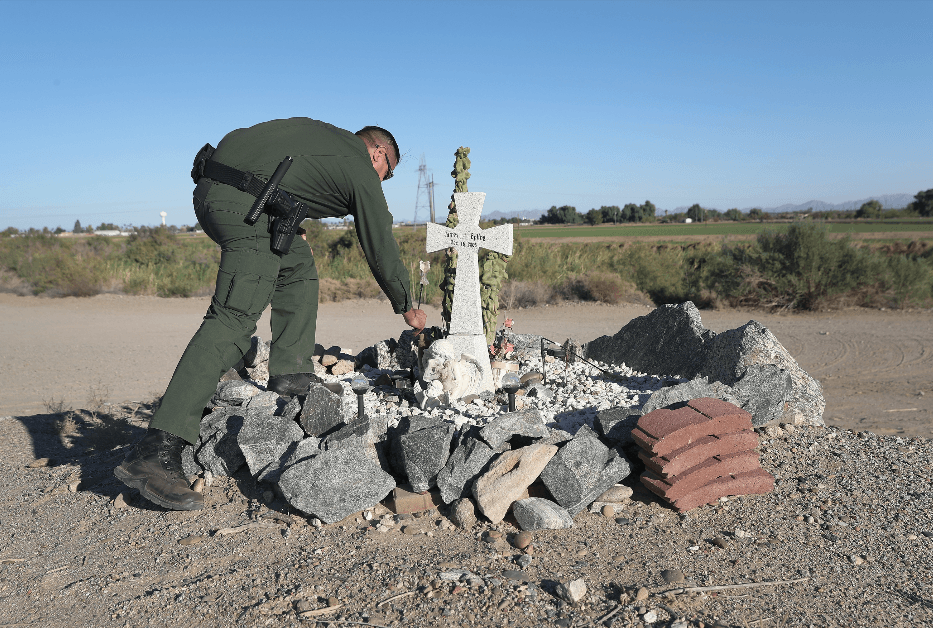 A Border Patrol agent adjusts adornments on a memorial for fallen agent James Epling in Andrade, Calif., on Nov. 17, 2016. (John Moore/Getty Images)