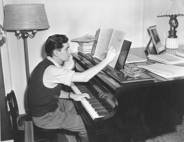 American conductor, composer, and pianist Leonard Bernstein works on a new musical score in his apartment in New York City on Feb. 24, 1945. Twenty-eighteen marks the 100th anniversary of Bernstein's birth. (AP Photo, File)