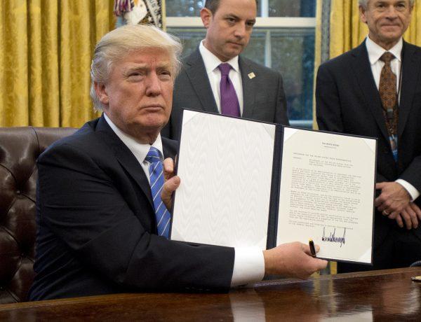 President Donald Trump shows the executive order withdrawing the United States from the Trans-Pacific Partnership on Jan. 23. (Ron Sachs - Pool/Getty Images)