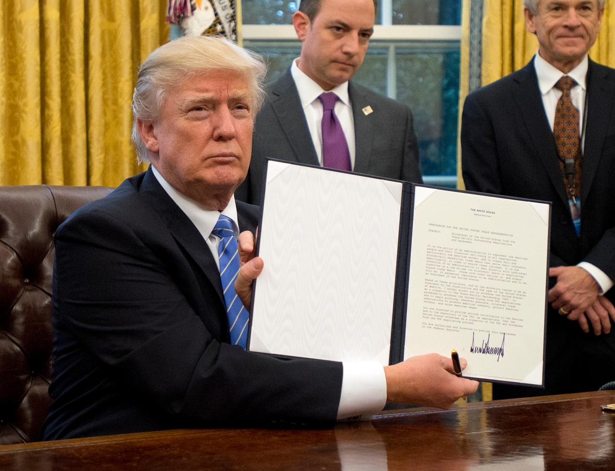 President Donald Trump shows the executive order withdrawing the United States from the Trans-Pacific Partnership on Jan. 23, 2017. (Ron Sachs - Pool/Getty Images)