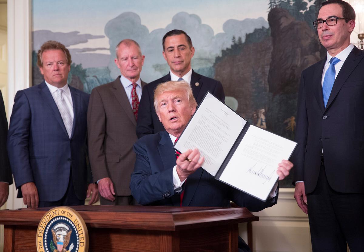 President Donald Trump signs a memorandum on addressing China's laws, policies, practices, and actions related to intellectual property, innovation, and technology, at the White House in Washington on Aug. 14, 2017. (Chris Kleponis-Pool/Getty Images)