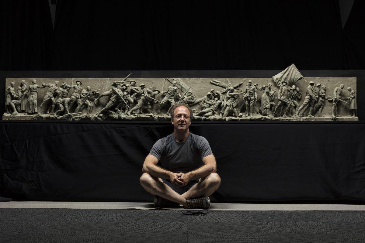 Sculptor, Sabin Howard sits with the maquette he created for "A Soldier's Journey," the sculptural component of the National World War I Memorial, at Weta Workshop in Wellington, New Zealand, in November 2017. (Courtesy of Sabin Howard)
