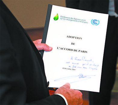 Former French President François Hollande holds a copy of the 196-nation Paris Agreement in Paris on Oct. 5. The United States withdrew from the accord in part because it gives major polluters like China and Russia a free pass and punishes U.S. industry. (JACQUES DEMARTHON/AFP/GETTY IMAGES)