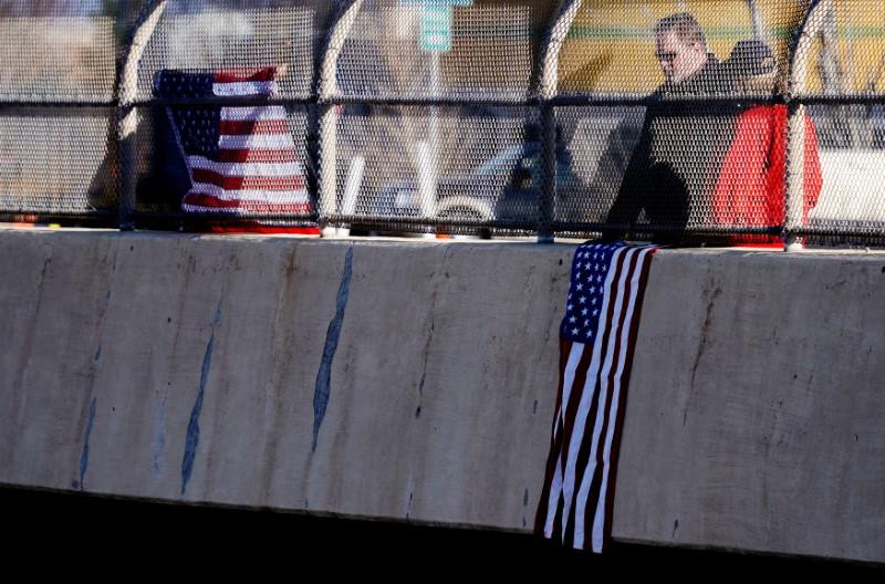 People watch a procession of police vehicles escort the hearse carrying the body of a deputy killed in a domestic disturbance where multiple deputies and civilians were shot in Highlands Ranch, Colorado, on Dec. 31, 2017. (REUTERS/Rick Wilking)