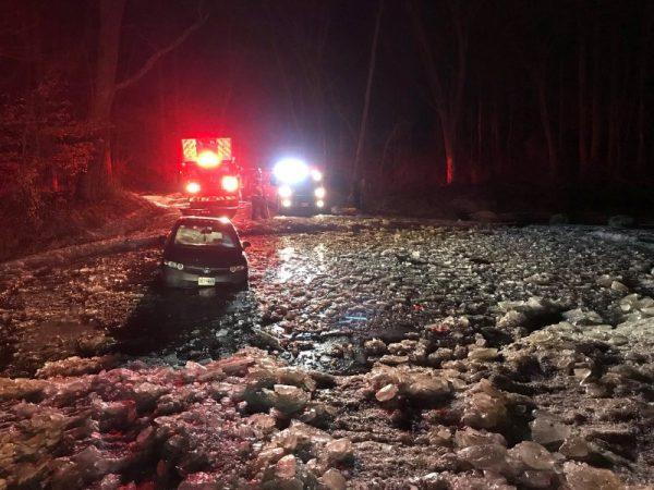 Firefighters rescue three people after a car was stuck in icy water in Boyds, Maryland, U.S., in this Jan 1, 2018 image by Montgomery County Fire and Rescue Service obtained from social media. (Montgomery County Fire and Rescue Service/Social Media/via Reuters)
