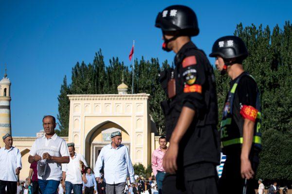 Police patrol the streets as Uyghurs leave the Id Kah Mosque in the old town of Kashgar in Xinjiang, on June 26, 2017. (Johannes Eisele/AFP/Getty Images)