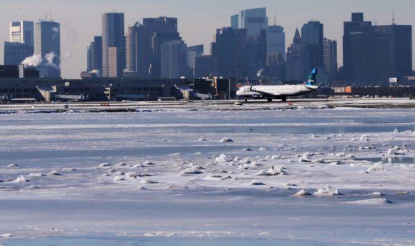 Ahead of an incoming winter snow storm, a Jet Blue flight waits to take off from Logan International Airport next to the frozen waters of the Atlantic Ocean harbour between Winthrop and Boston, Massachusetts, U.S., Jan. 3, 2018. (Reuters/Brian Snyder)
