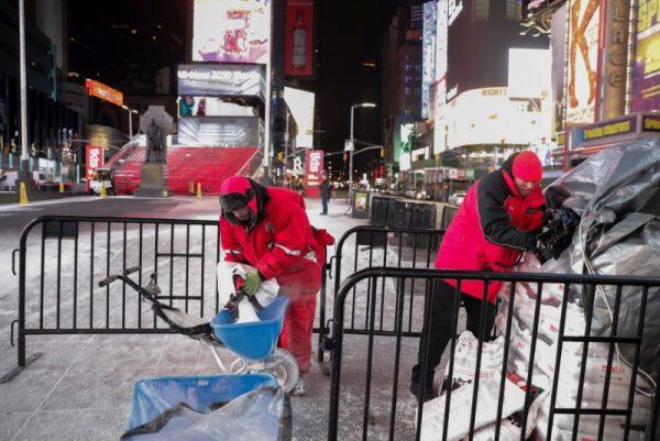 Work crews dump road salt during a snowstorm in Times Square in Manhattan, New York, U.S., Jan. 4, 2018. (Reuters/Jeenah Moon)