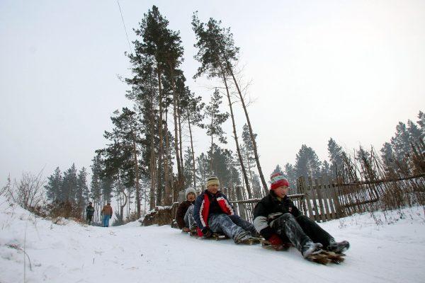 Children ski on a homemade sled in Yichun City of Heilongjiang Province, on January 9, 2006. (China Photos/Getty Images)