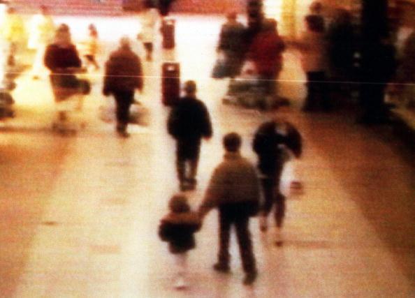 A surveillance camera shows the abduction of two-year-old James Bulger from the Bootle Strand shopping mall near Liverpool, England on Feb. 12, 1993, at 3:42 p.m. Bulger holds the hand of Jon Venables, one of two ten-year-old boys later convicted of his torture and murder. (BWP Media via Getty Images)