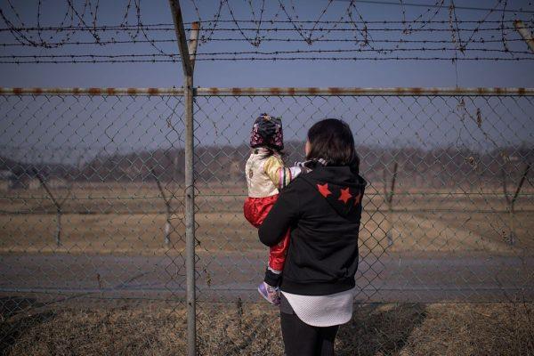 A woman holding a child looks towards North Korea as they stand at a military fence at Imjingak Park, south of the Military Demarcation Line and Demilitarized Zone (DMZ) separating North and South Korea, on Feb. 19, 2015. South Korean families separated during the Korean war often visit the DMZ to offer prayers for their relatives in the North, on the occasion of the Lunar New Year. (Ed Jones/AFP/Getty Images)