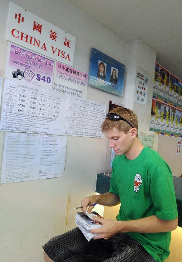 A tourist waits to inquire about entry visas to China at a Chinese mainland operated travel company in Hong Kong on April 07, 2008. (Mike Clarke/AFP/Getty Images)