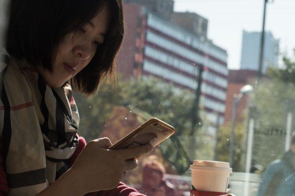  A woman uses her smartphone in Beijing on Nov. 11, 2017. (Fred Dufour/AFP/Getty Images)