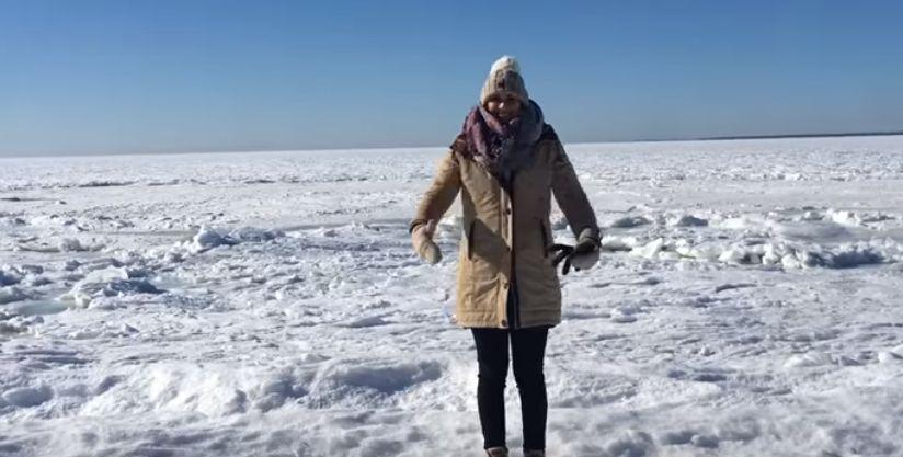 Dangerous: A woman walks over the bay in Falmouth, Massachusetts, which froze over due to plunging temperatures. (YouTube video - Ryan Canty / screenshot)