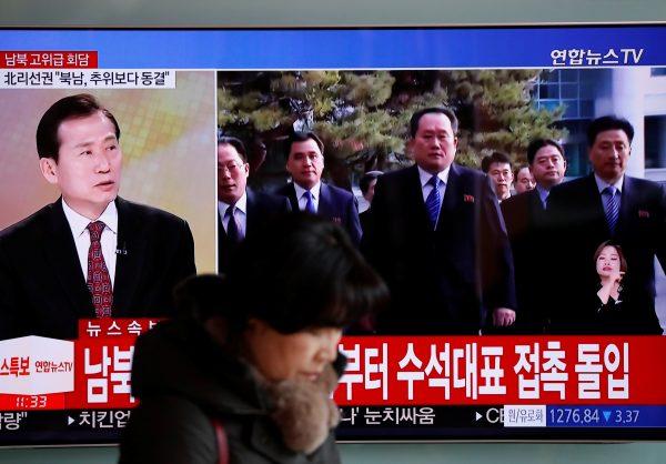 A woman walks past a TV broadcasting a news report on a high-level talks between the two Koreas at the truce village of Panmunjom, in Seoul, South Korea, Jan. 9, 2018. (Reuters/Kim Hong-Ji)
