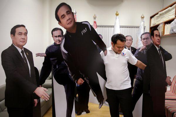 A government official arranges cardboard cut-outs of Thailand's Prime Minister Prayuth Chan-ocha at Government House in Bangkok, Thailand, Jan. 9, 2018. (Reuters/Athit Perawongmetha)