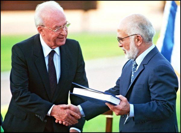 Hussein Ibn Talal, King of Jordan (R) and Israeli Premier Yitzhak Rabin shake hands after they exchanged the documents of the Peace Treaty on the southern shore of the Sea of Galilee on Nov. 10, 1994. (SVEN NACKSTRAND/AFP/Getty Images)