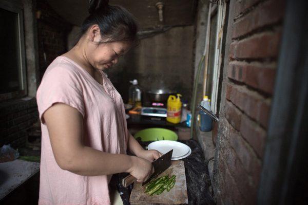 A woman cooks in a communal kitchen in a migrant village on the outskirts of Beijing, on September 7, 2017. (Nicolas Asfouri/AFP/Getty Images)