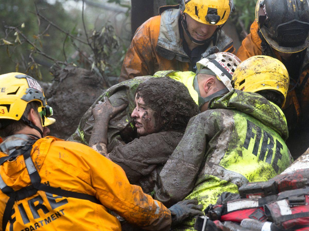 Emergency personnel carry a woman rescued from a collapsed house after a mudslide in Montecito, California, U.S. Jan. 9, 2018. (Kenneth Song/Santa Barbara News-Press via Reuters)