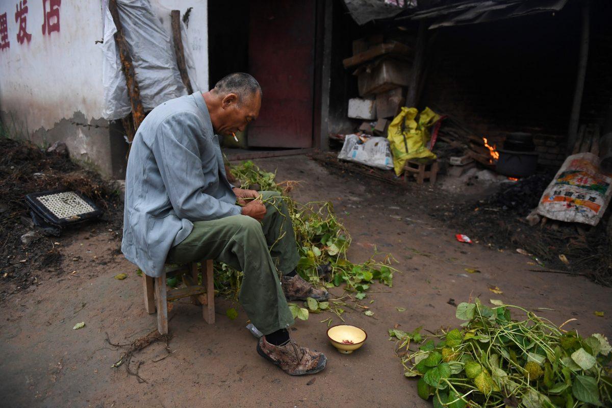 A man preparing beans outside his house in a village near the Yellow River in Lankao county, Henan Province, on Sept. 28, 2017. (Greg Baker/AFP/Getty Images)