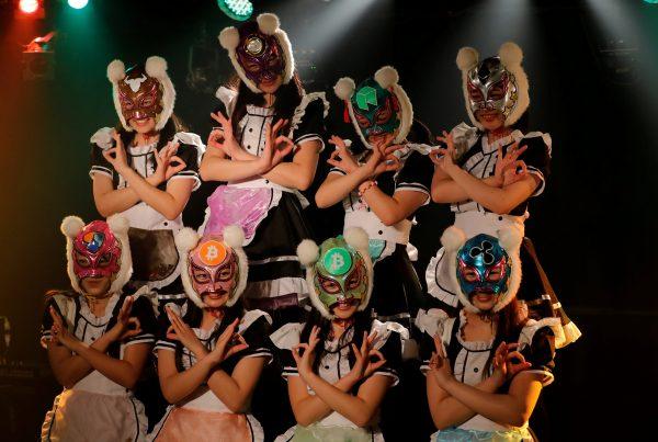 Members of Japan's idol group "Virtual Currency Girls" wearing cryptocurrency-themed masks pose after performing in their debut stage event in Tokyo, Japan, Jan. 12, 2018. (Reuters/Kim Kyung-Hoon)
