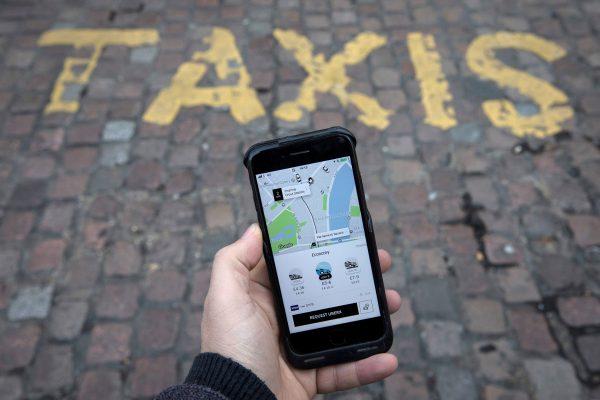 FILE PHOTO: A photo illustration shows the Uber app on a mobile telephone, as it is held up for a posed photograph, in London, Britain, November 10, 2017. (Reuters/Simon Dawson/File Photo)