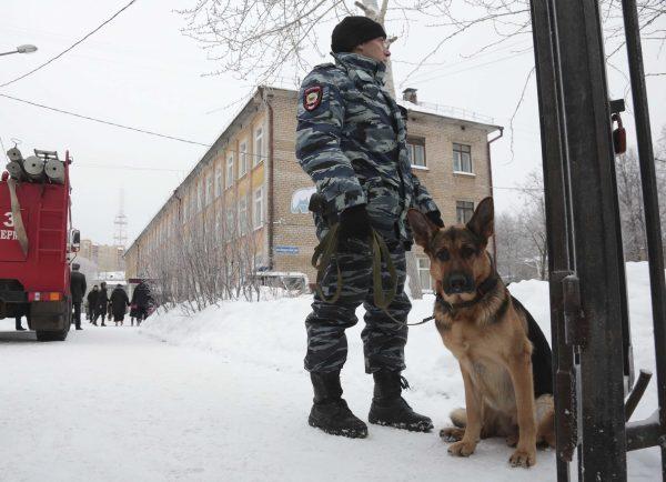 A policeman with a dog stands guard near a local school after reportedly several unidentified people wearing masks injured schoolchildren with knives in the city of Perm, Russia Jan. 15, 2018. (Reuters/Maksim Kimerling)