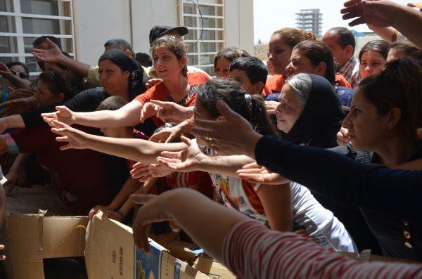 Refugees on the run in the Ankawa region in Northern Iraq beg NGO volunteers for food and water. (Allen Kakony)