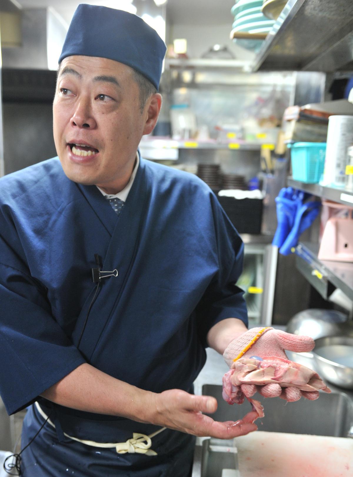 A Japanese chef shows the liver of a pufferfish, at his restaurant in Tokyo, June 2012. (Yoshikazu Tsuno/AFP/GettyImages)