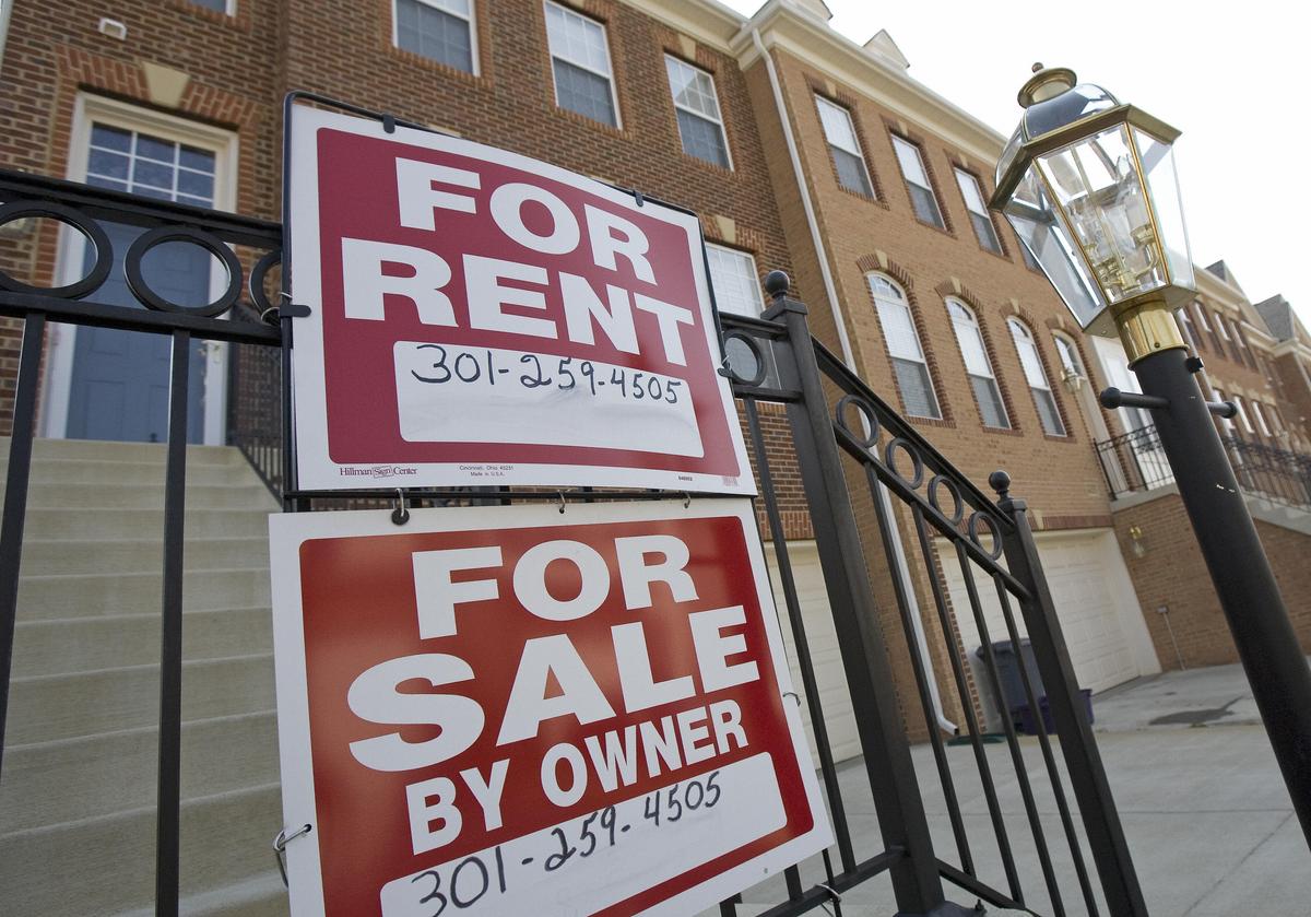 "For Rent" and "For Sale" signs are seen outside an apartment building. (Paul J. Richards/AFP/Getty Images)