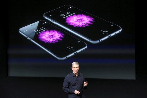 Apple CEO Tim Cook stands in front of a screen displaying the IPhone 6 during a presentation at Apple headquarters in Cupertino, California on Oct. 16, 2014. (Reuters/Robert Galbraith/File Photo)